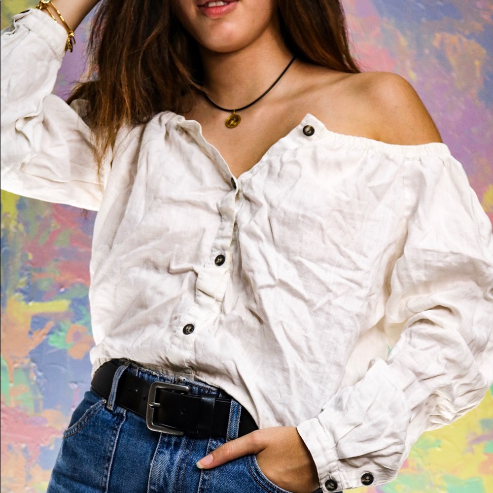 Long sleeved, off the shoulder white blouse.